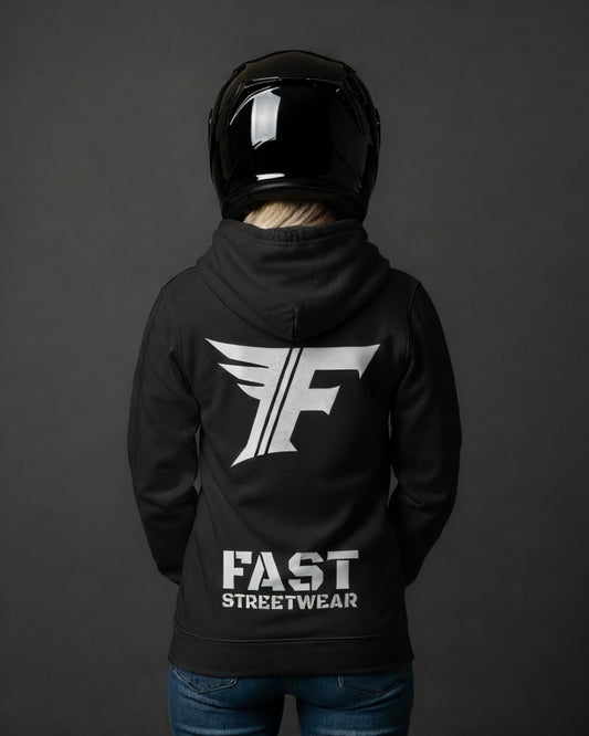 Black hoodie worn by a blonde woman facing away, wearing a black motorcycle helmet. Features a large white graphic of a stylized 'F' with wings and the text "FAST STREETWEAR" on the back.