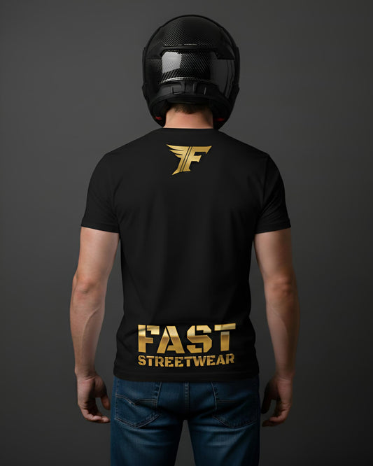 A black t-shirt, viewed from the back on a person wearing a motorcycle helmet, features a small gold 'F' logo on the upper back and large gold text saying 'FAST STREETWEAR' near the bottom.