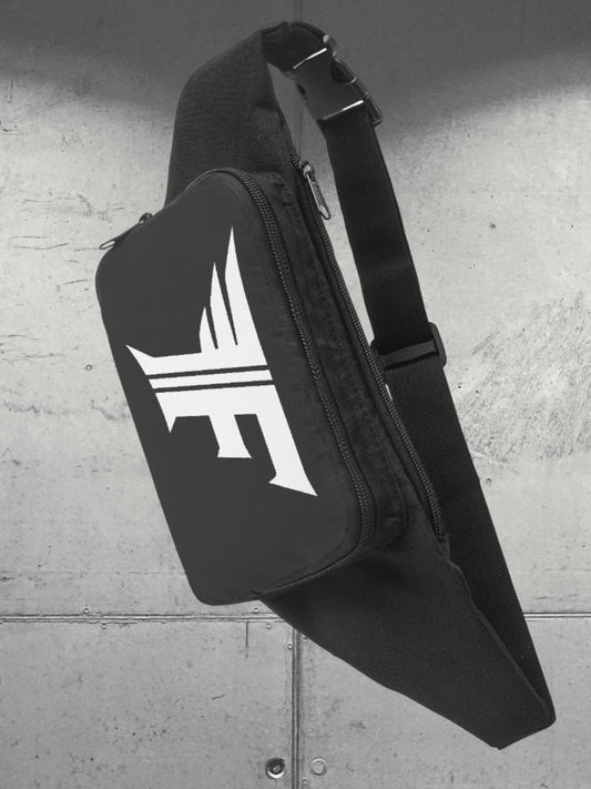 Black sling or fanny pack with a white winged 'F' logo, showing the adjustable strap and buckle. Presented against an industrial, gray wall.