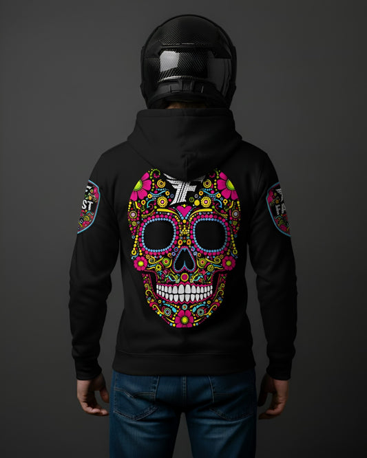 Back view of black hoodie with an oversized, multi-colored sugar skull graphic covering the entire back. Model wears a carbon fiber motorcycle helmet.