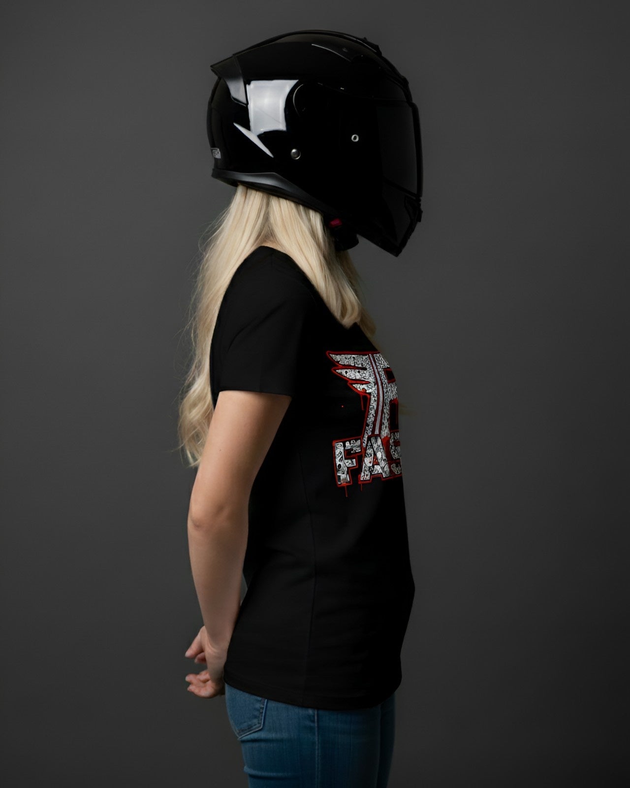 A woman in a black motorcycle helmet and a "Fast" streetwear superbike t-shirt, showcasing motorcycle enthusiast apparel and an art shirt.