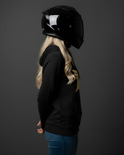 Person wearing a black helmet and black hoodie with a gold design on a dark background