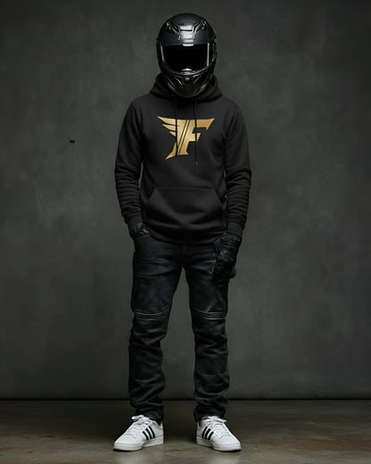 Man in full-face helmet wears black superbike t-shirt hoodie with gold winged "F" logo, black jeans, and sneakers. Motorcycle enthusiast apparel.