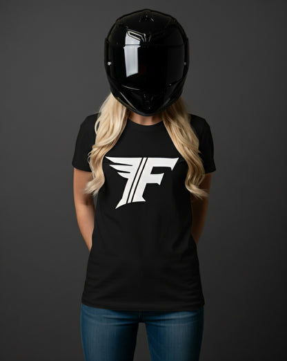 A blonde woman in a black motorcycle helmet, wearing a black t-shirt featuring a stylized white logo with an 'F' and wings.
