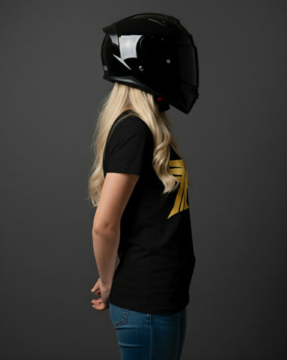 Person wearing a black helmet and black t-shirt with a gold logo on a dark background