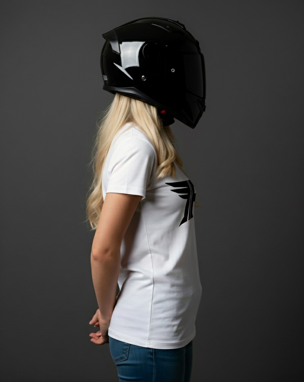 Person wearing a black helmet and black t-shirt with a white design on a dark background