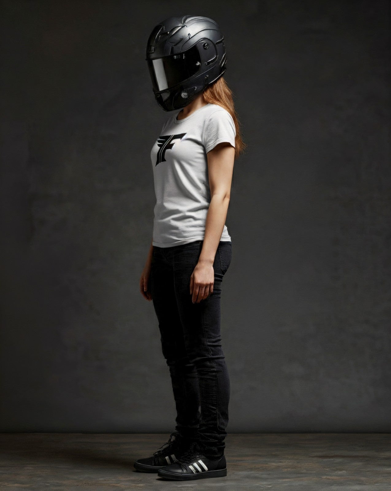Person wearing a black helmet and white t-shirt with a logo on a dark background