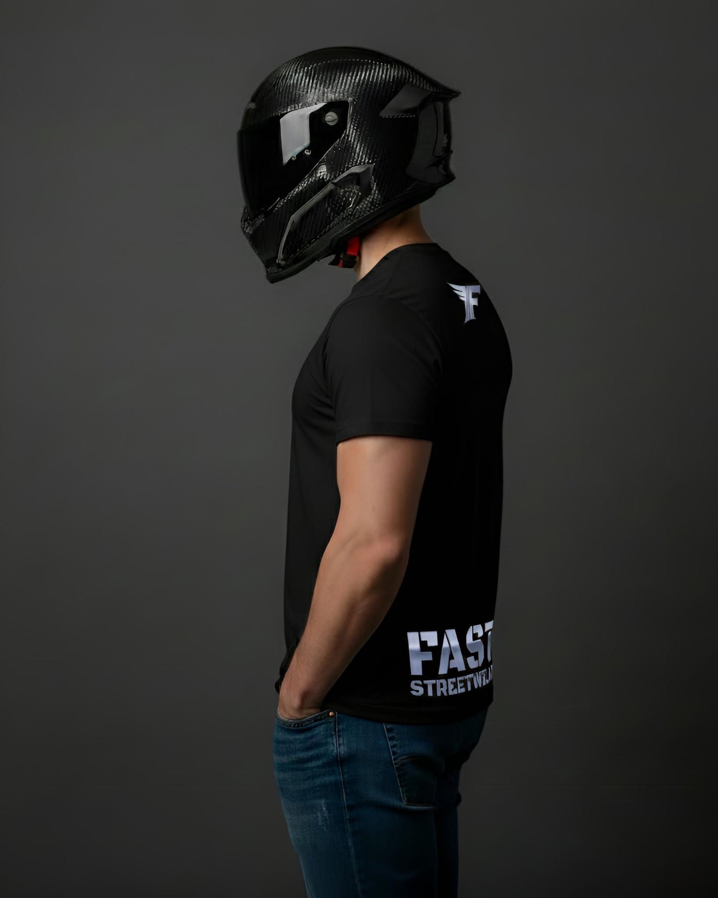 Person wearing a black helmet and black t-shirt with 'FAST' branding on a dark background