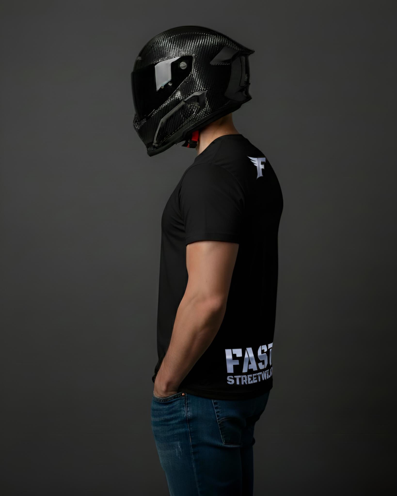 Person wearing a black helmet and black t-shirt with 'FAST' branding on a dark background