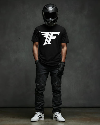 Person wearing a black t-shirt with a logo, black helmet, leather pants, and white sneakers on a dark background