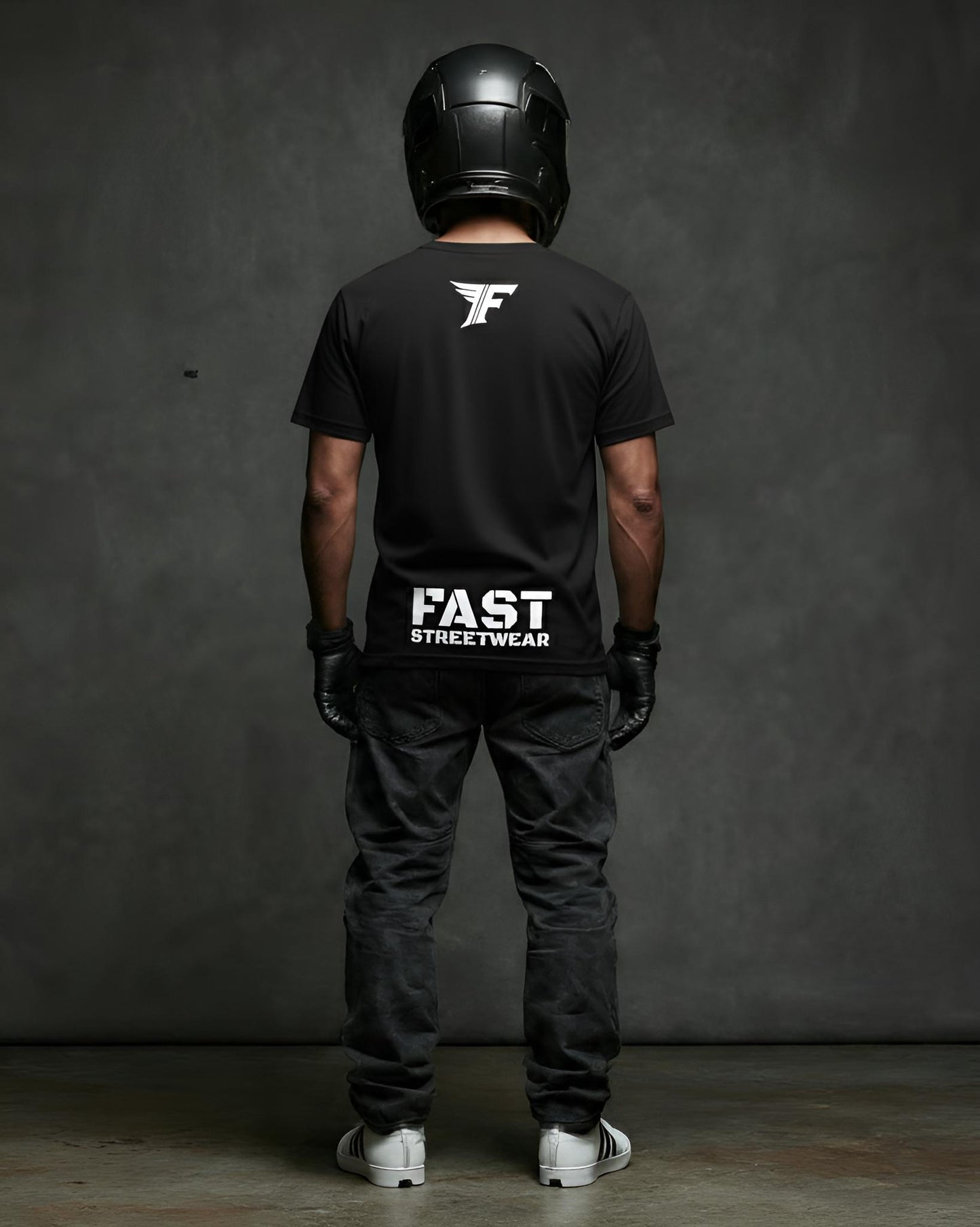 Person wearing a black t-shirt with 'FAST Streetwear' logo, black helmet, and dark pants against a gray background.