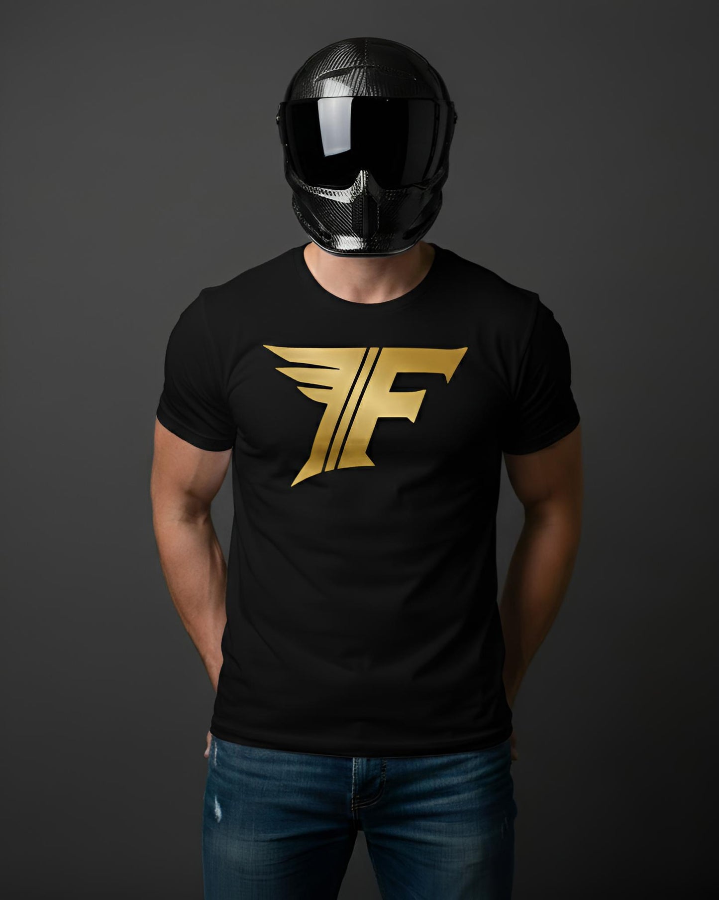 Black t-shirt featuring a large, stylized gold "F" logo with wing designs, worn by a man in a carbon fiber helmet and jeans.