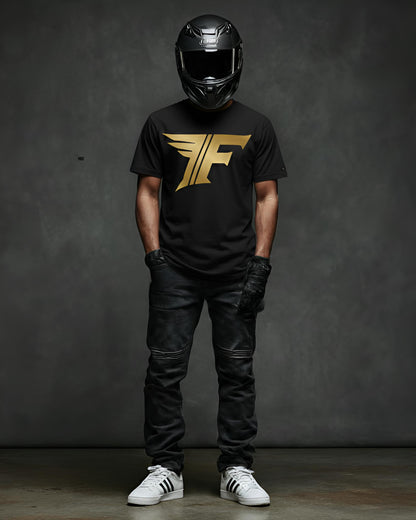 A man wearing a black shirt featuring a gold "F" logo with wings, black jeans, motorcycle gloves, a helmet, and white sneakers.