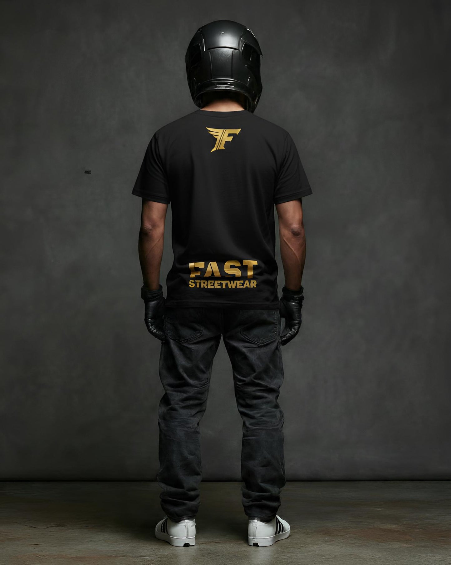 Black t-shirt featuring a gold wing logo and the bold gold text "FAST STREETWEAR" on the back, modeled by a person wearing a helmet and gloves.