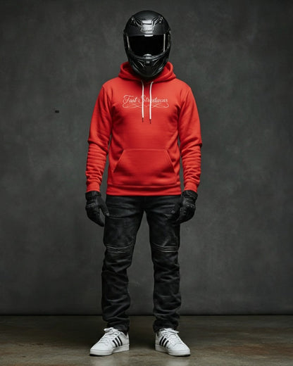 Person wearing a red hoodie, black helmet, leather pants, and white sneakers against a dark background