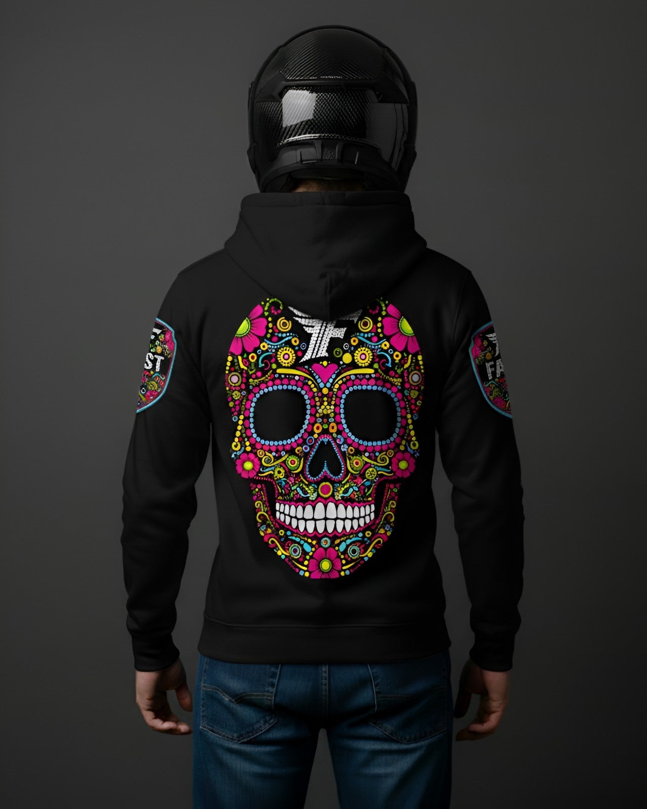 Back view of black hoodie with an oversized, multi-colored sugar skull graphic covering the entire back. Model wears a carbon fiber motorcycle helmet.