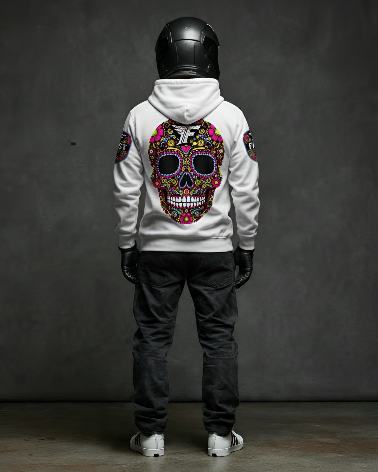 Back view of a white pullover hoodie with a large, colorful sugar skull graphic. Modeled with a black motorcycle helmet.