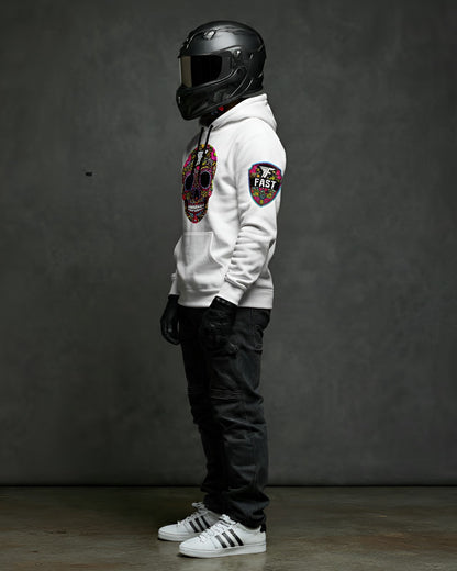 Left side view of the white sugar skull hoodie, showcasing the shield patch on the sleeve. Model wears a black helmet and jeans.