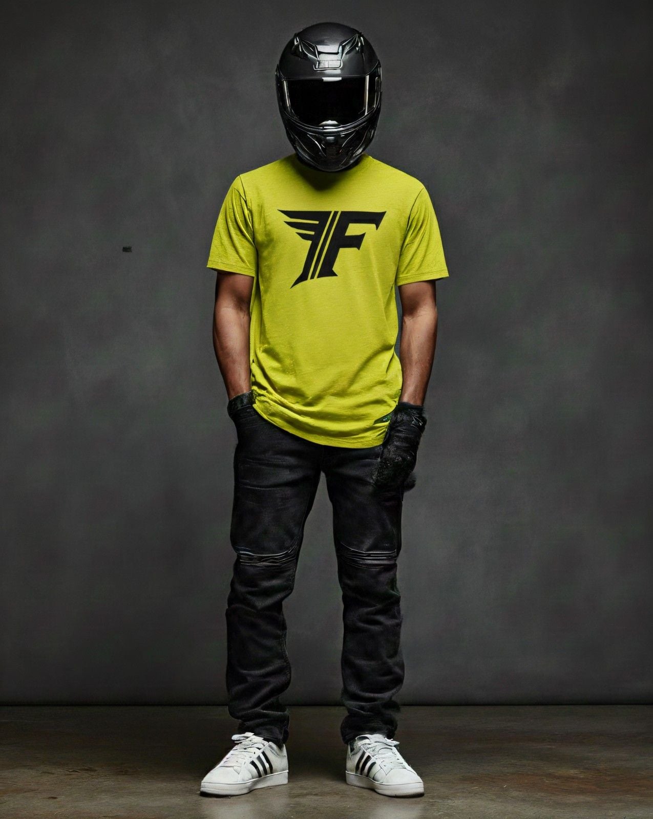Men's bright yellow crewneck tee featuring a black winged graphic logo. Model wears black jeans and a helmet.