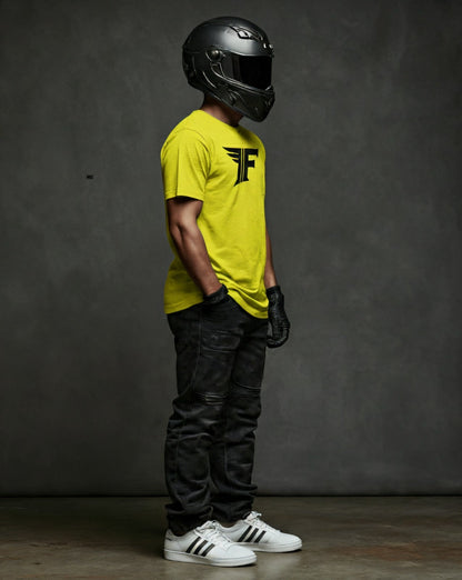 Bright yellow crew-neck t-shirt with a black "F" logo, modeled by a person wearing a helmet, gloves, and jeans in a side view.