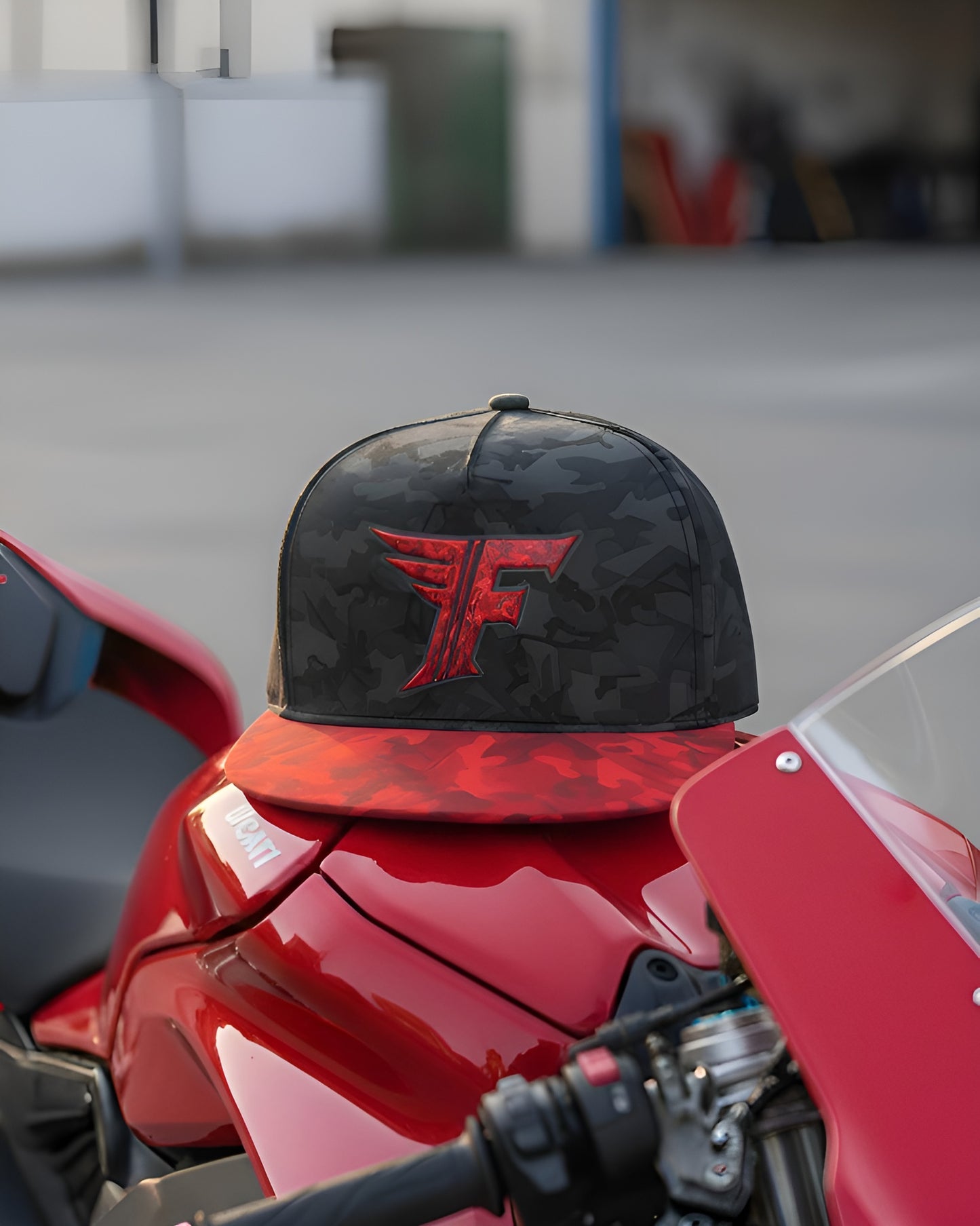 Black and red cap with a logo on a red motorcycle in an outdoor setting